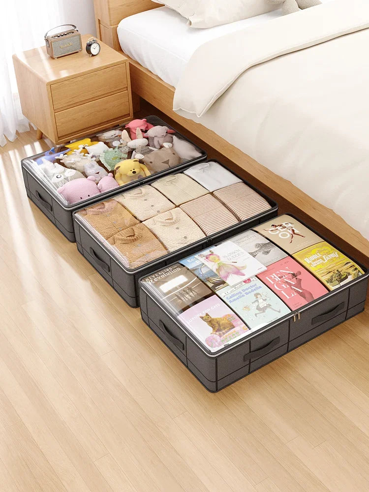 A set of foldable under-bed storage boxes filled with various soft toys and fabric items on a light wooden floor.