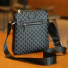 A black men's lightweight crossbody sling bag with a textured pattern resting on a wooden surface.