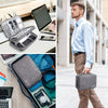 A man wearing a blue shirt and brown pants stands outdoors, holding a gray leather cable storage organizer bag.
