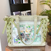 A transparent shoulder tote bag with a light green fabric and decorative ribbon details.