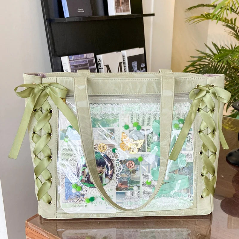 A transparent shoulder tote bag with a light green fabric and decorative ribbon details.