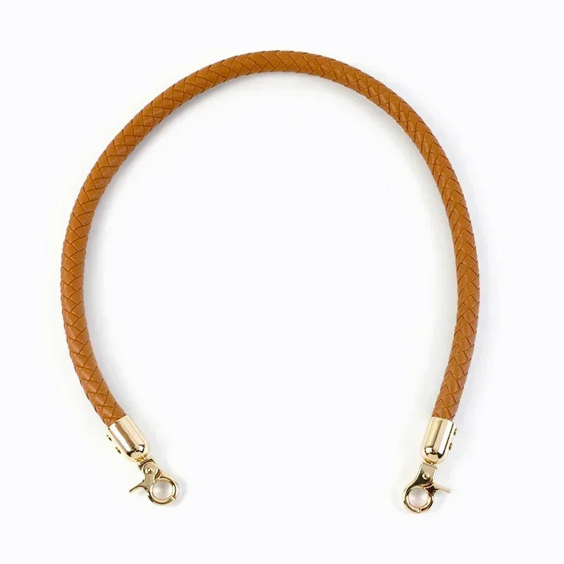 A close-up of a brown leather strap with metal buckles, used as a replacement bag handle.