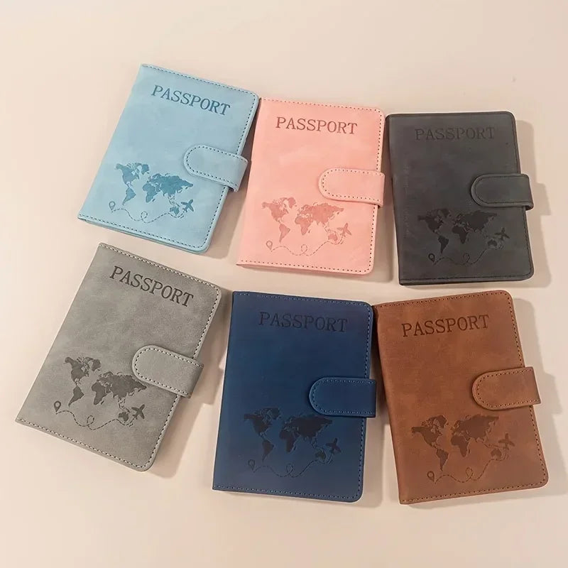 A collection of five passport wallets in various colors including blue, pink, gray, black, and brown leather.