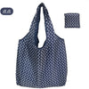 A dark blue reusable eco tote shopping bag with white polka dots, shown in a hanging and folded view.