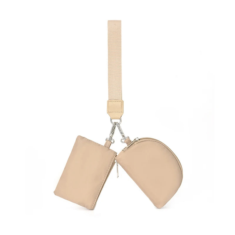 A beige dual zip keychain wallet wristlet with a light beige strap.