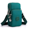 A teal nylon crossbody phone bag with a zipper and adjustable strap is shown against a white background.