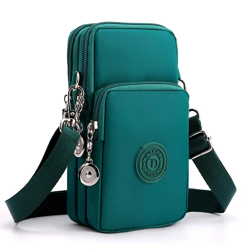 A teal nylon crossbody phone bag with a zipper and adjustable strap is shown against a white background.