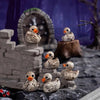 A set of small, realistic duck figurines resembling skulls and feathers displayed in a rustic outdoor setting.