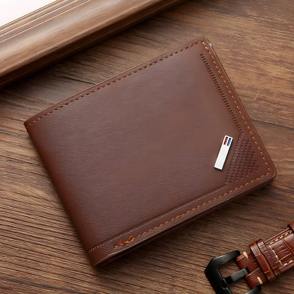 A brown leather wallet with a money clip is shown resting on a wooden surface.