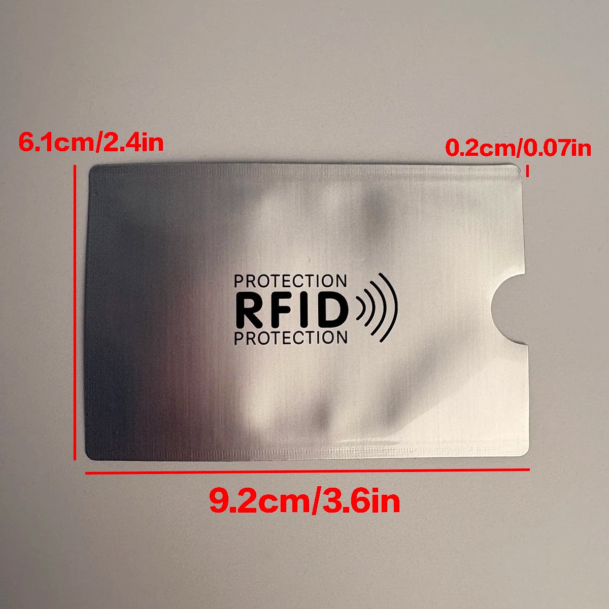 A silver RFID protection card sleeve with dimensions 9.2cm x 6.1cm, featuring an RFID protection logo.