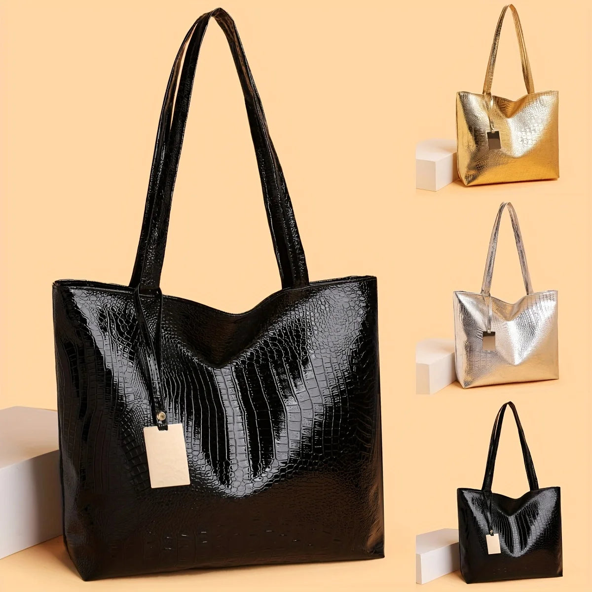 A black crocodile-textured leather tote bag with gold hardware displayed against a beige background.