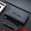 A dark blue leather wallet with personalized name engraving and a black pen lying next to it.