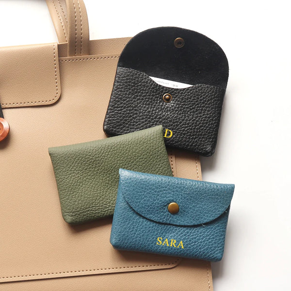 A collection of genuine leather card holders and coin purses in shades of tan, olive green, and black.