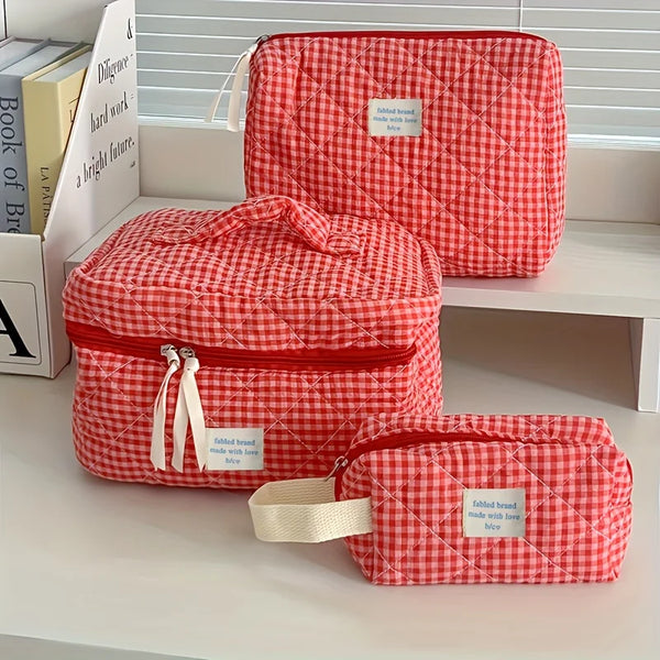 Un sac de rangement cosmétique à carreaux rouge et blanc est exposé sur une étagère blanche.