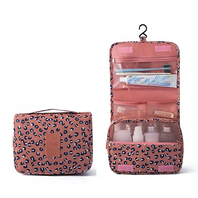 A pink multi-compartment travel pouch with a floral leopard print design, featuring various storage sections.
