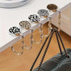 A display of gold-toned zinc alloy folding handbag hooks featuring various leopard and zebra print designs.