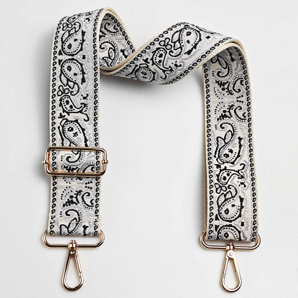 Beigefarbener gemusterter Lederriemen mit goldfarbenem Zierwerk für eine verstellbare Crossbody-Handtasche.