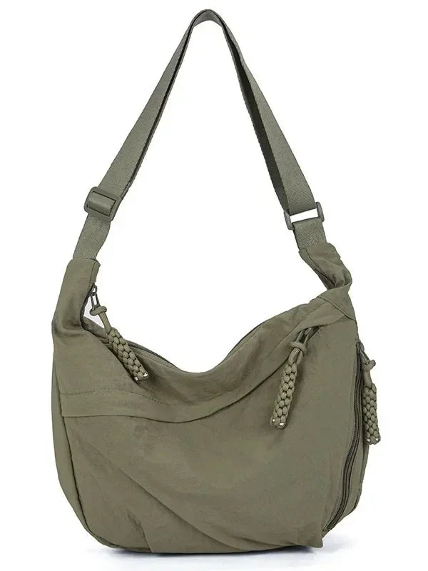 A soft olive green nylon crossbody shoulder bag with an adjustable strap.