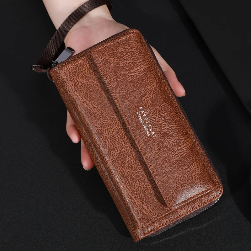 Portefeuille à fermeture éclair en cuir marron pour homme tenu dans la main sur fond sombre.