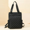 A black quilted women's backpack tote bag with black straps resting on a light background.