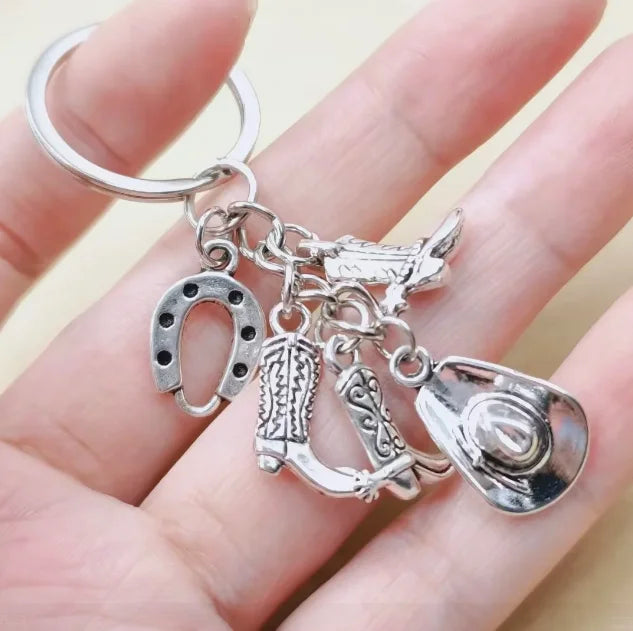Silver keychain set featuring a cowboy boot, hat, and horseshoe charms