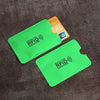 A bright green card sleeve protecting an ID card, with a yellow RFID card visible nearby.