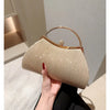 A beige pleated glitter evening handbag with a gold top handle and chain strap being held by a hand.