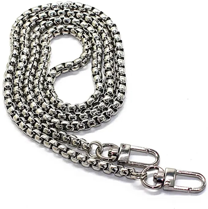 A silver stainless steel diamond-cut curb chain bag strap coiled and extended.
