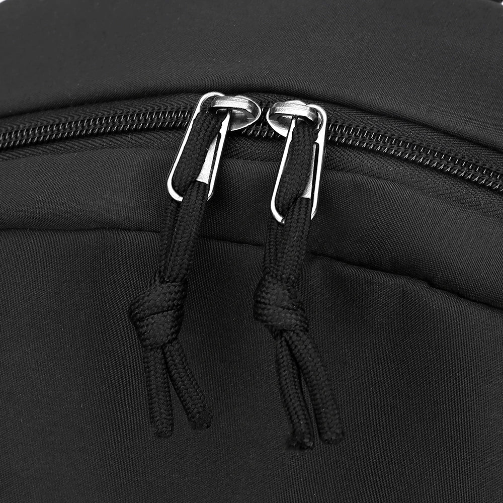 Close-up of a black leisure shoulder backpack featuring silver zipper pulls and black drawstrings.