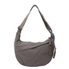 A gray canvas crossbody bag with adjustable straps and a drawstring closure.