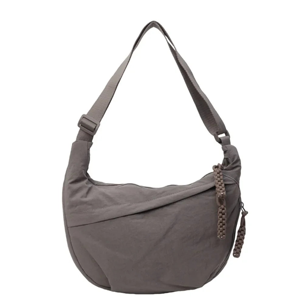 A gray canvas crossbody bag with adjustable straps and a drawstring closure.