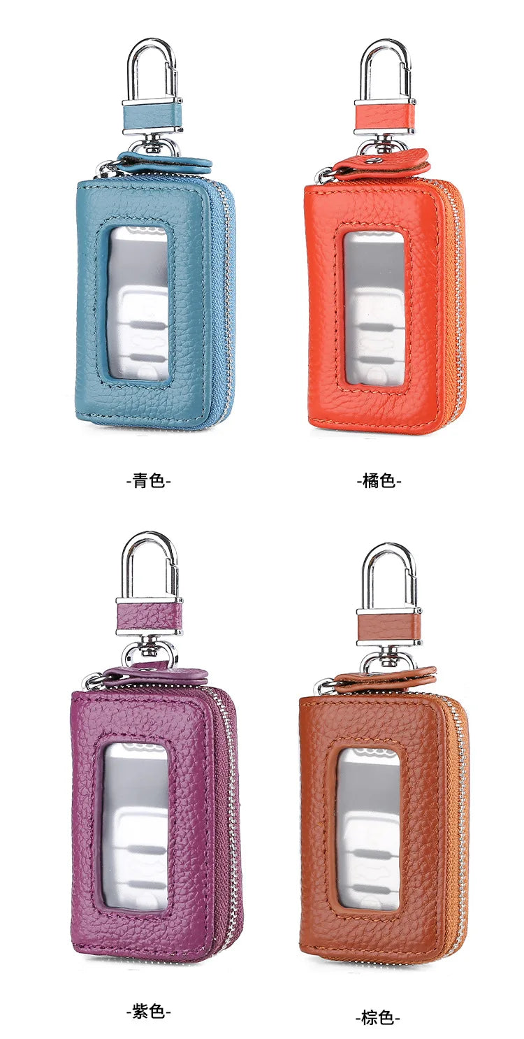 Four leather key cases in blue, orange, purple, and brown with transparent windows displayed side by side.