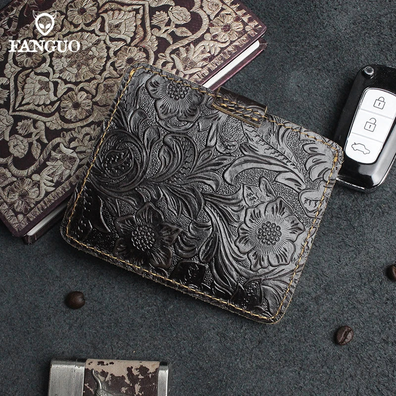 A black genuine leather card wallet with gold stitching is displayed on a dark gray surface next to an open notebook.