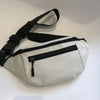 A light beige compact nylon waist bag with black straps and a zippered compartment.