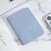 A light blue ultra-thin multi-slot card wallet resting on a white marble surface.