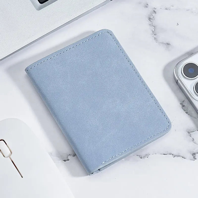 A light blue ultra-thin multi-slot card wallet resting on a white marble surface.