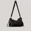 A black vintage washed leather tote bag with a long strap is shown against a light gray background.