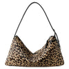 A close-up of a brown and black leopard print vintage horsehair and cowhide crossbody bag.