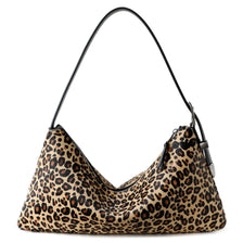 A close-up of a brown and black leopard print vintage horsehair and cowhide crossbody bag.