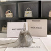 Silver crystal-embellished evening clutch with a chain displayed on a white surface.