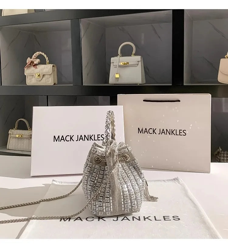 Silver crystal-embellished evening clutch with a chain displayed on a white surface.