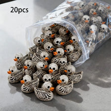 A pile of 20 gothic skull duck figurines in a clear plastic bag