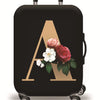 A black suitcase with a gold initial A design featuring pink and white flowers.