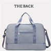 A light blue nylon travel duffle bag shown from the back with a zippered pocket and shoulder straps.