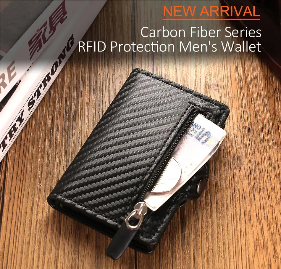 A black carbon fiber wallet with a zipper is shown resting on a wooden surface.