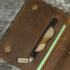A brown leather trifold wallet with a black zipper and a gold-toned chain holding coins.