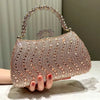 A close-up of a rose gold crystal-embellished evening clutch bag with a chain strap resting on a surface.