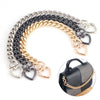 A curved display of heart-shaped metal chains in silver, black, and gold.