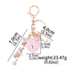 Gold-toned key chain featuring a heart charm and a dangling beaded chain.