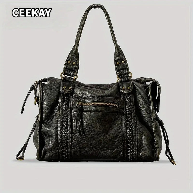 A black vintage washed leather tote bag with gold hardware shown against a light gray background.